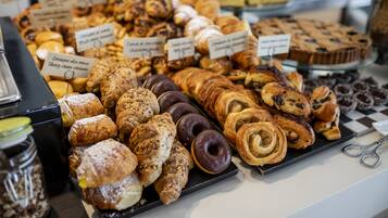 Una exposición de pasteles y productos horneados con etiquetas que indican sus nombres y sabores.