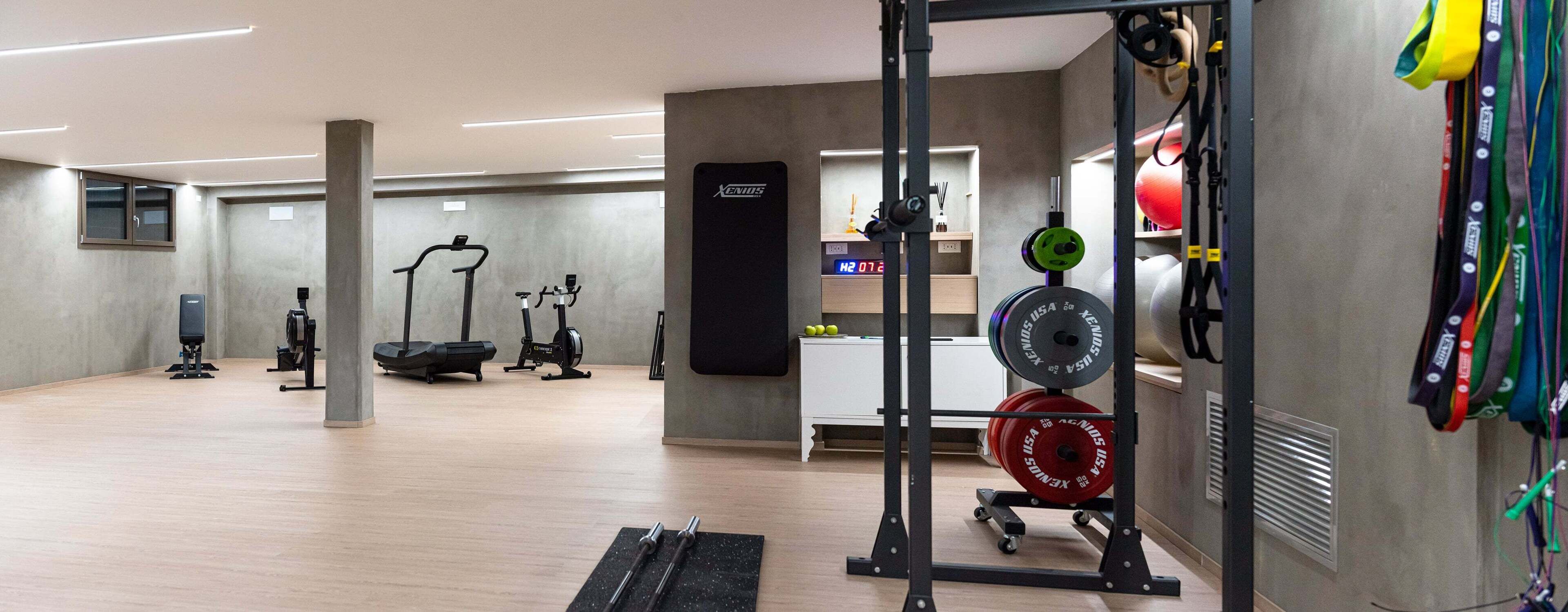 A gym with exercise equipment, a weightlifting rack, and a digital scale.