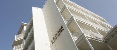 A high-rise hotel with multiple balconies and a clear sky.