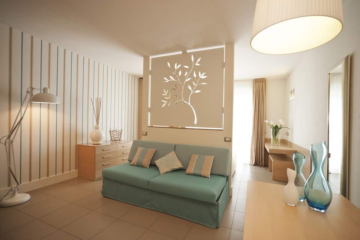 A modern living room with a sofa, a lamp, and decorative vases.