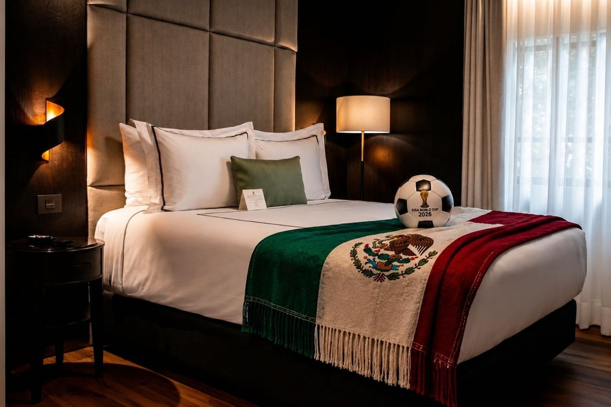 Una habitación de hotel con una cama grande, una mesita de noche, una lámpara y una ventana con cortinas.