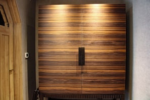 A large wooden wardrobe with a central handle and a textured surface.