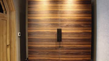 A large wooden wardrobe with a central handle and a textured surface.