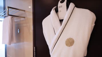 Bata blanca con un parche circular en el pecho, exhibida en un maniquí en un entorno comercial.
