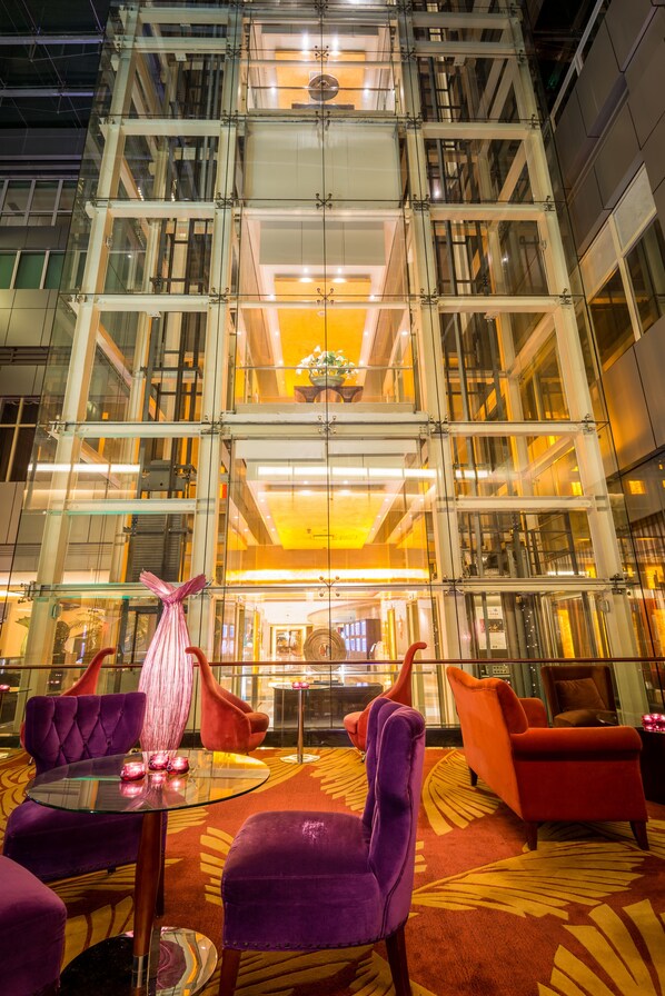 A lobby with a glass facade, a central chandelier, and purple and orange seating. - Pullman Guangzhou Baiyun Airport (Guangzhou)