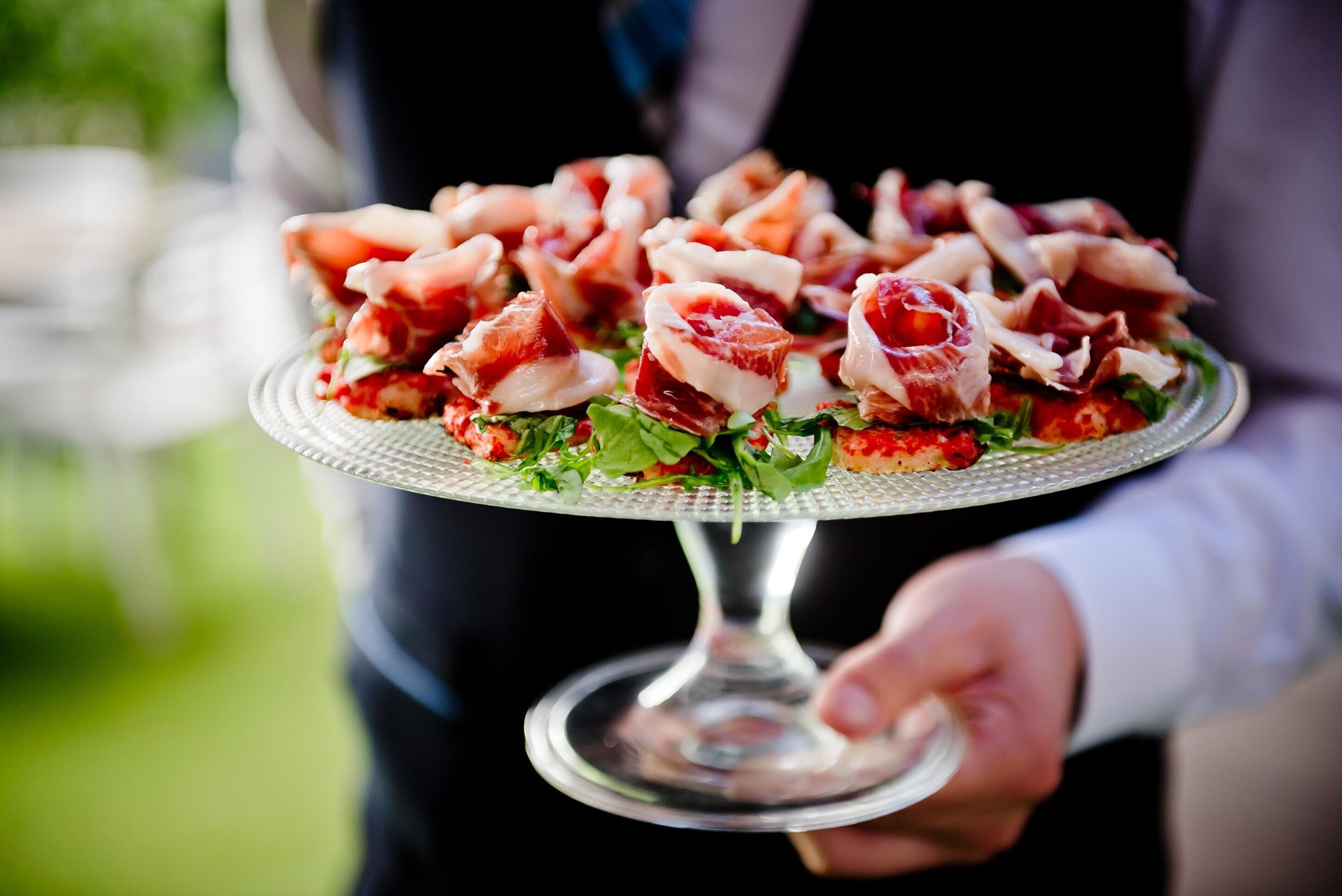 A person holding a plate with food items.