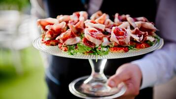 A person holding a plate with food items.