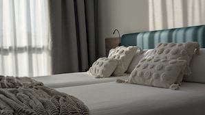 Une chambre à coucher moderne avec un lit, des oreillers et une couverture.