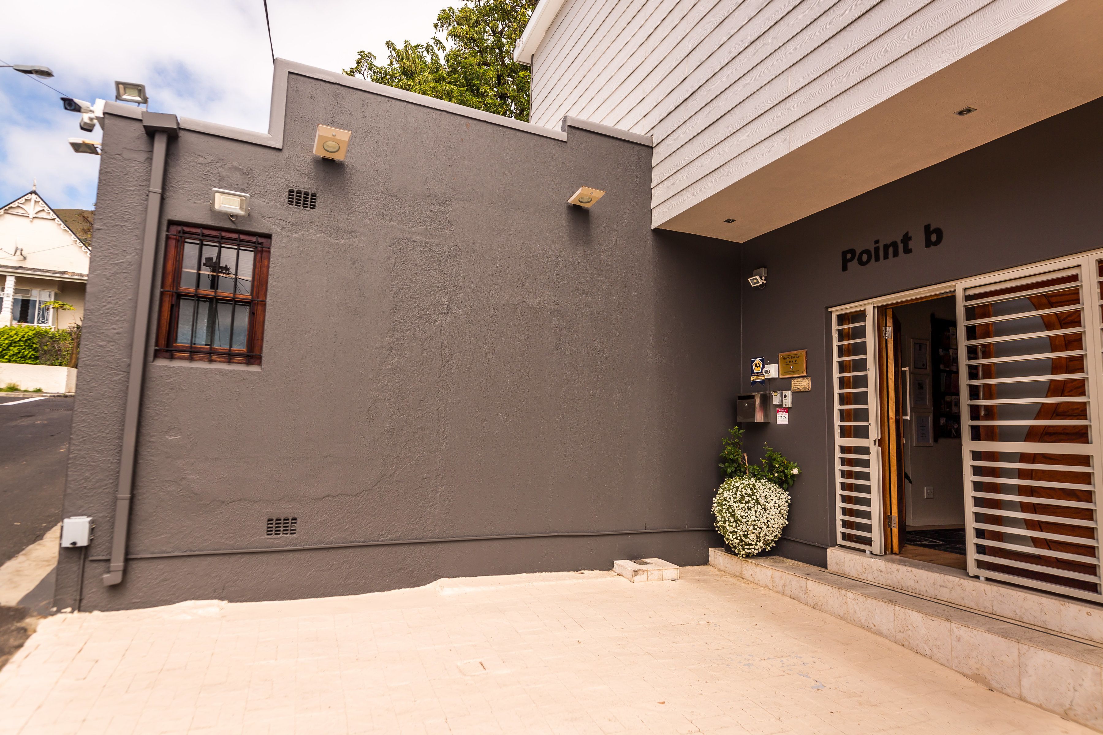 A building facade with a grey exterior, a window, and a sign reading "Point b".