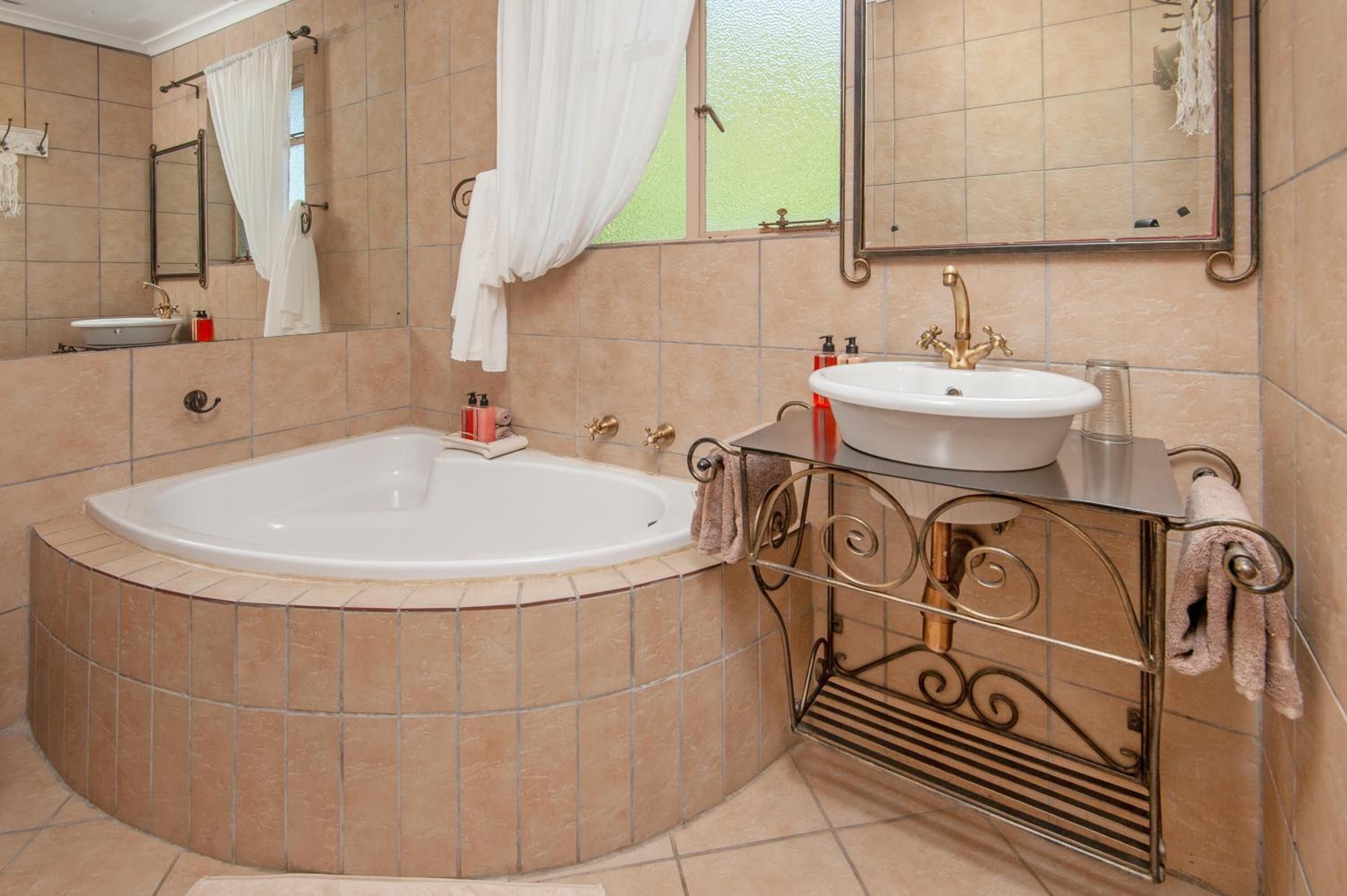 Ein Badezimmer mit freistehender Badewanne, einem Waschtisch und einem großen Spiegel.
