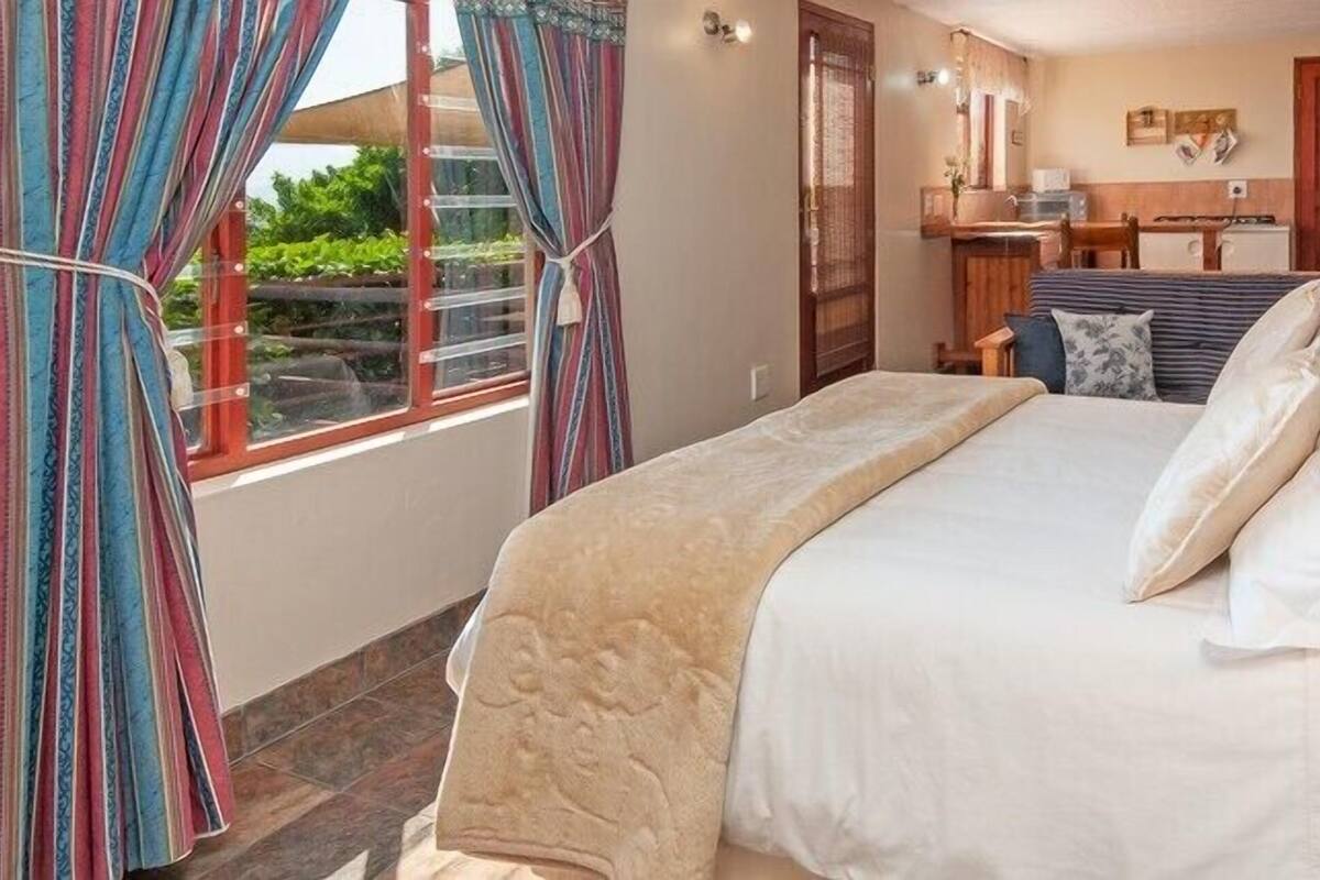 Ein Hotelzimmer mit Bett, Schreibtisch und Blick ins Freie.