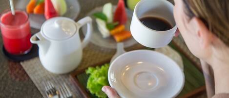 A breakfast setting with a plate of food, a cup of coffee, and a glass of juice.