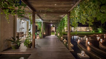 Una piscina al aire libre, sombrillas, sillones reclinables de piscina