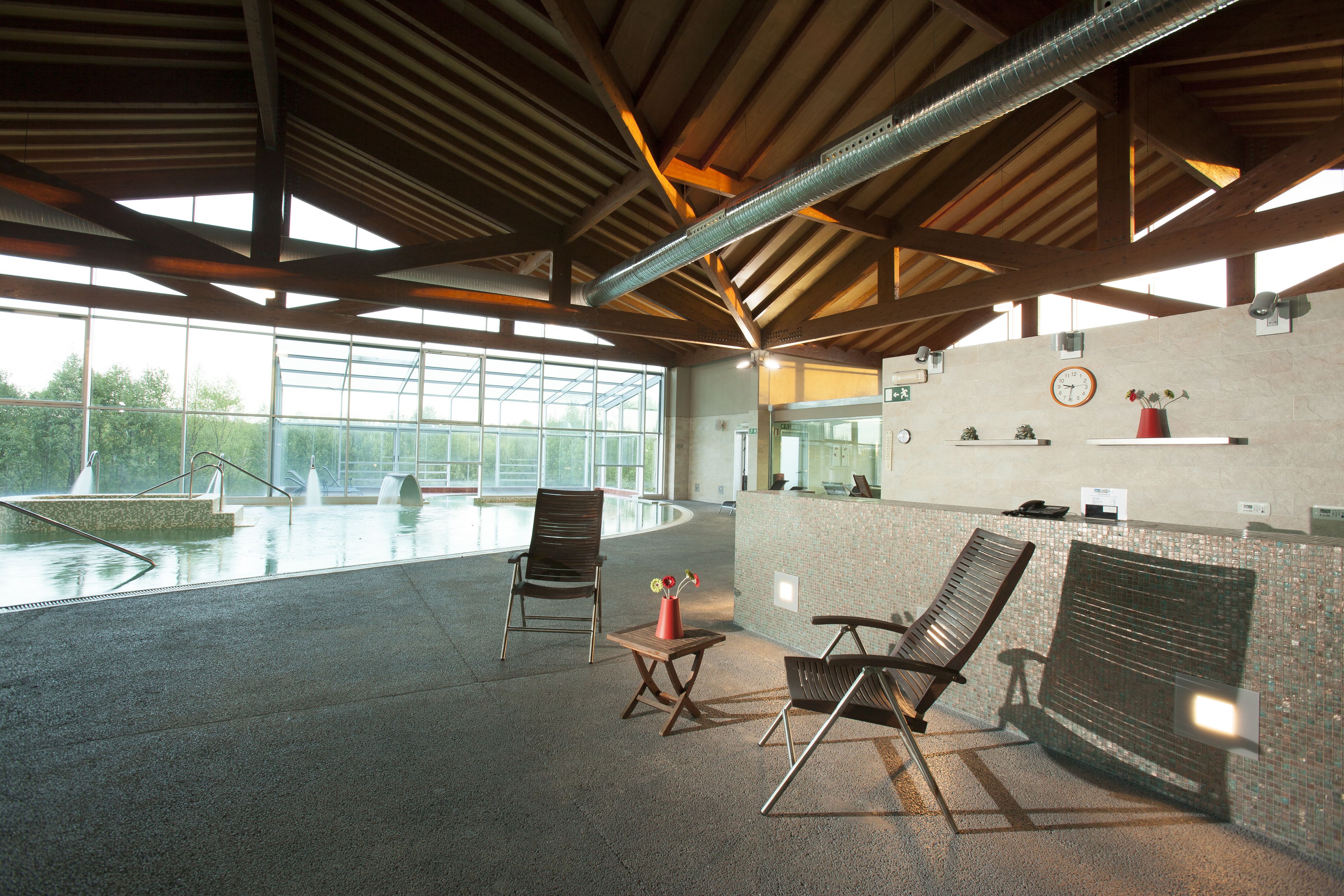 A spacious indoor area with a pool, seating, and a reception desk.