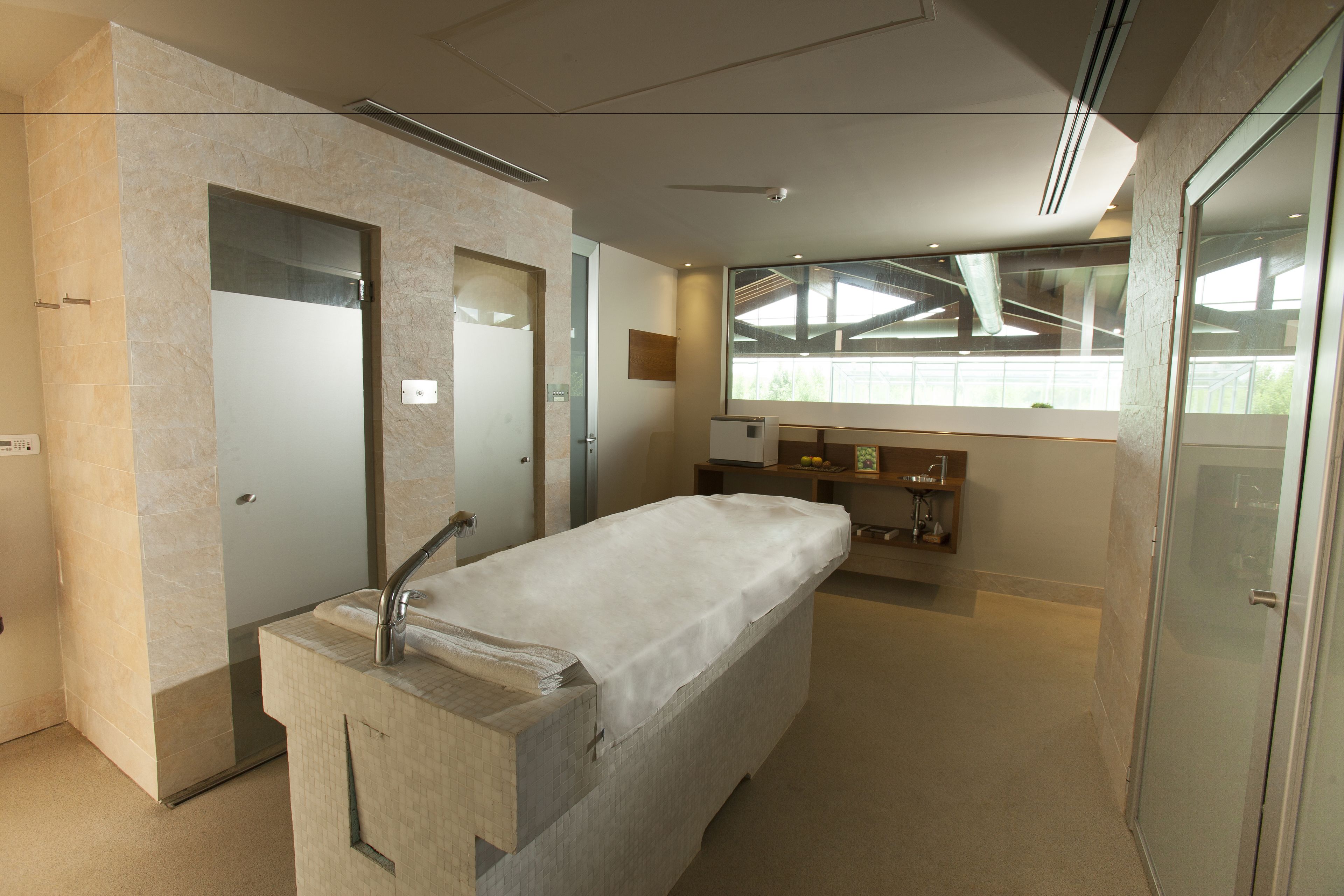 Een moderne badkamer met een grote spiegel, een wastafel met een handdoek, en een douche.