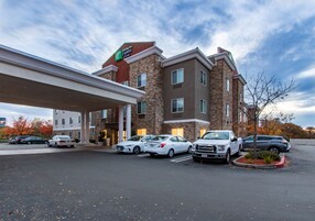 Un hotel con una stazione di servizio, diversi posti auto e un cielo sereno.