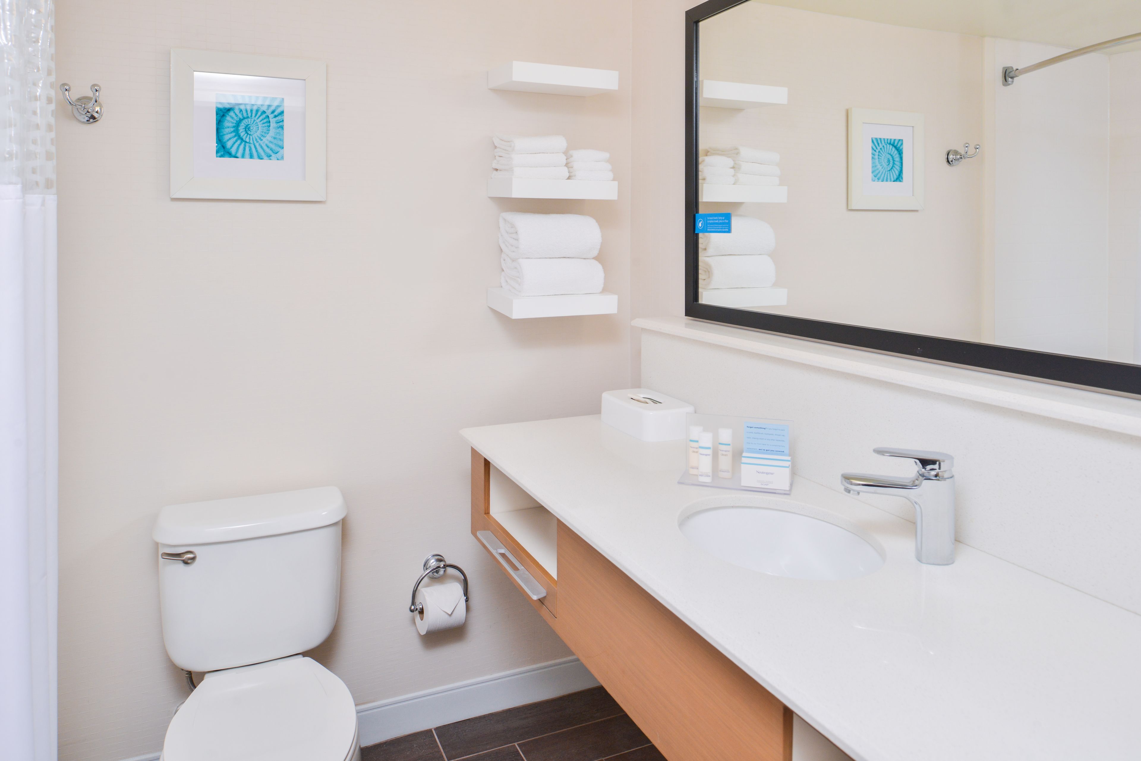 Un baño moderno con inodoro, lavabo y toalleros.