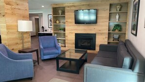 A modern living room with a fireplace, a television, and a bookshelf.