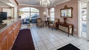 A spacious living area with a kitchen, a chandelier, a large mirror, and a view of the outside. - Econo Lodge Jasper (Jasper)