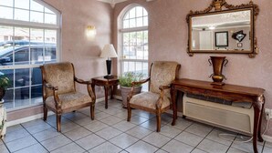 A room with three upholstered chairs, a table, a mirror, and a chandelier. - Econo Lodge Jasper (Jasper)