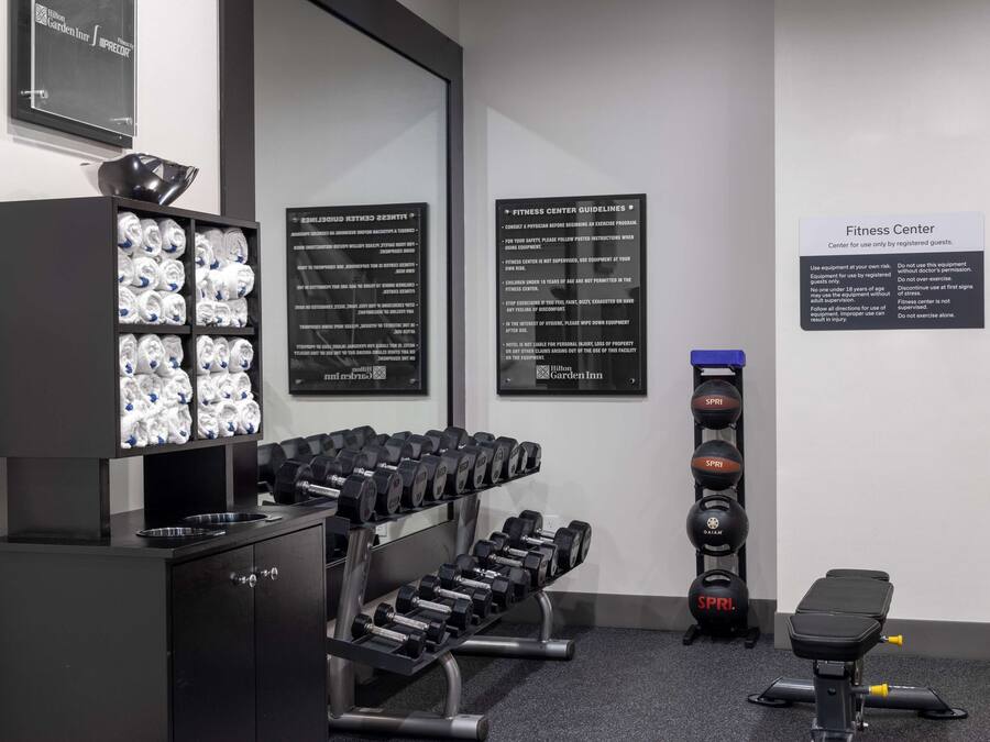 Un gimnasio con mancuernas, una banca y equipo de ejercicio.