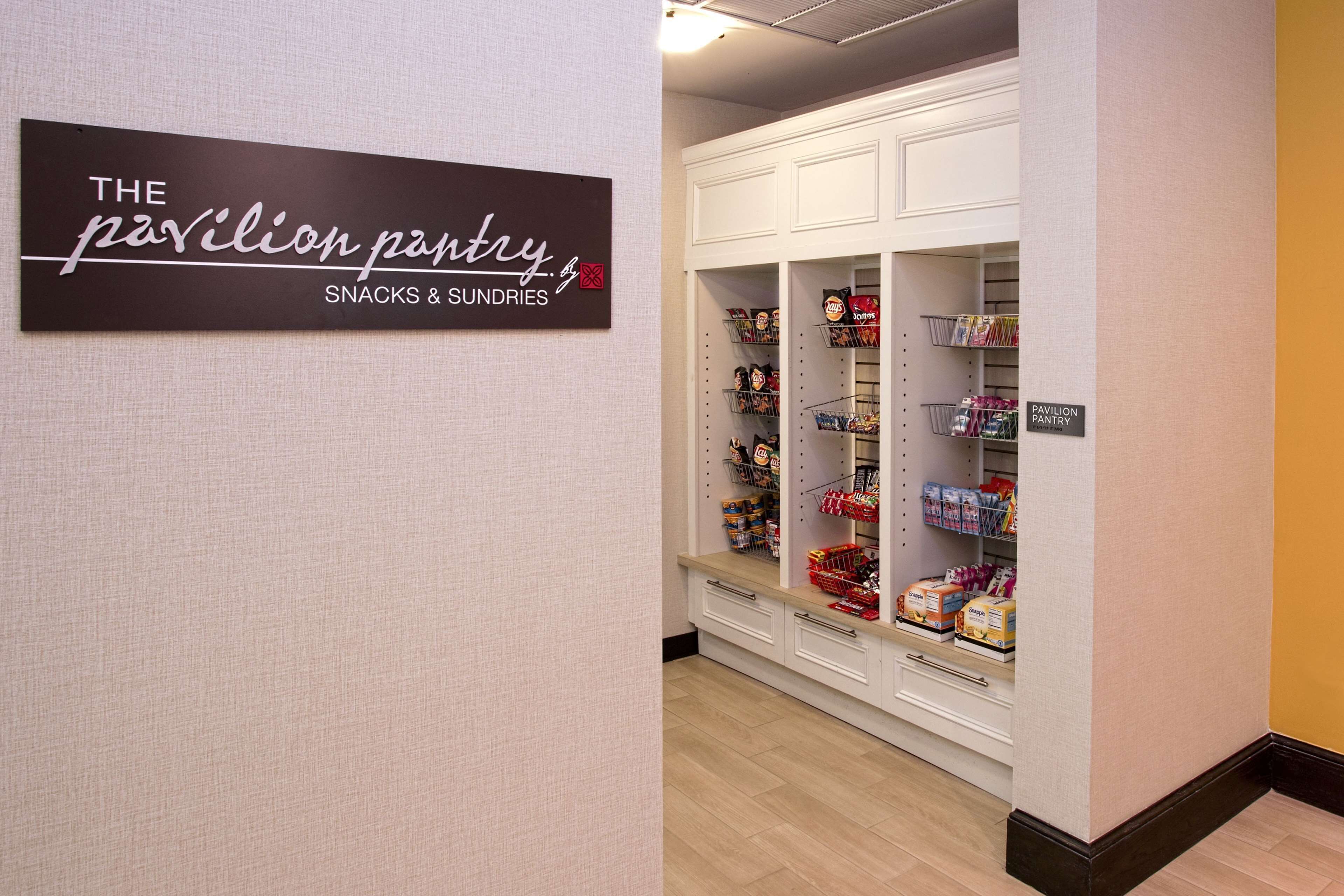 Ein Bereich eines Hotels, der als 'The Pavilion Pantry' ausgeschildert ist, mit Snacks und kleinen Artikeln.