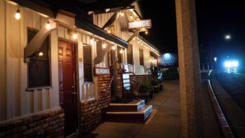 A hotel with a porch, a staircase, and a sign that reads "Office."