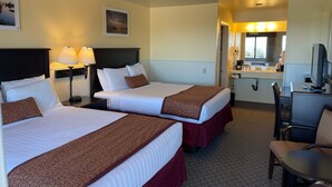 A hotel room with two beds, a desk, a chair, a TV, and a bathroom visible through an open door. - Yosemite Gateway Motel (Lee Vining)