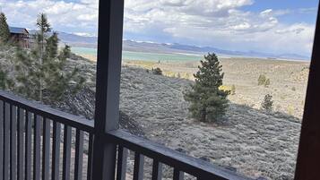 Un espace extérieur abrité offrant une vue sur un paysage montagneux et un plan d’eau.