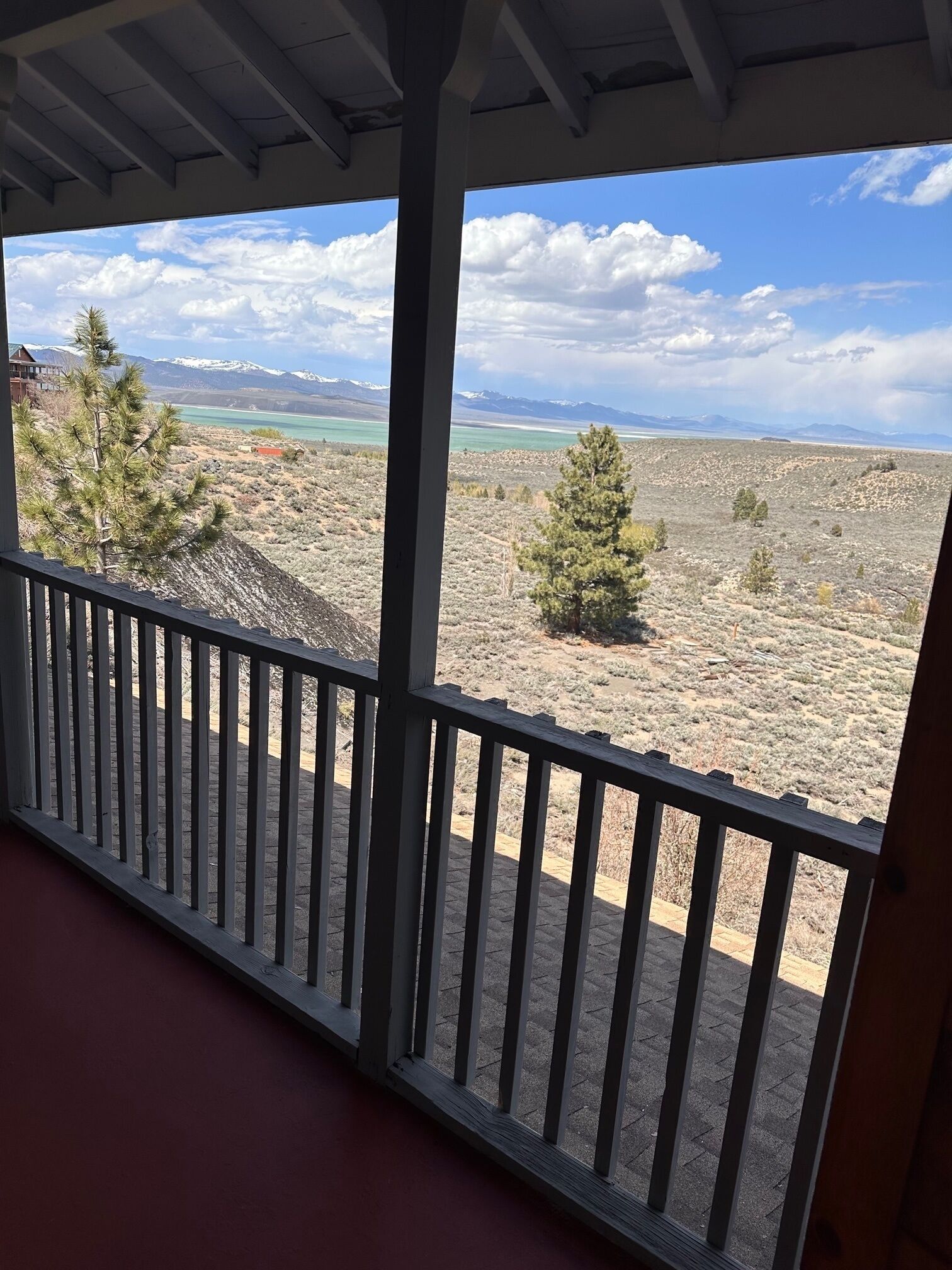 Un balcón con vistas a un paisaje desértico, montañas y un lago.