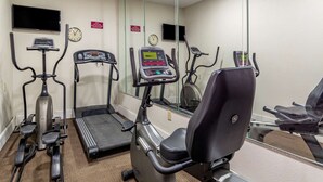 Une salle de remise en forme équipée de tapis de course, d’un vélo elliptique et d’un vélo d’appartement.