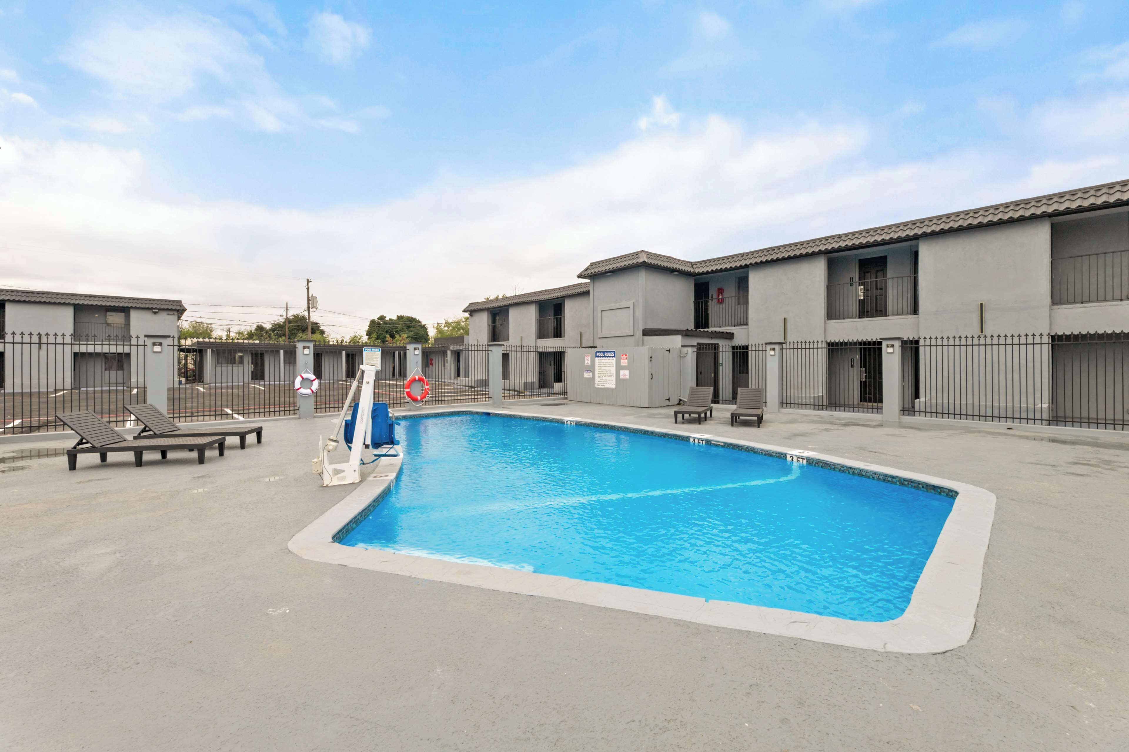 A swimming pool surrounded by buildings with a clear sky.
