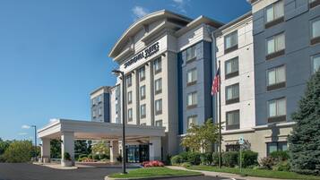 A hotel with a modern facade, a covered entrance, and a parking area with handicapped accessibility.