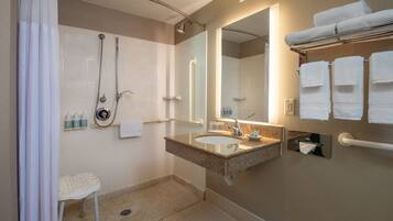 Een moderne badkamer met douche, wastafel en handdoekhouder.