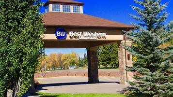 A Best Western hotel entrance with a clear sky, a brick pillar, and a sign.