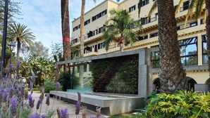 A modern building with balconies, surrounded by palm trees and a garden with lavender. - Hotel Escuela Santa Brígida (Santa Brigida)