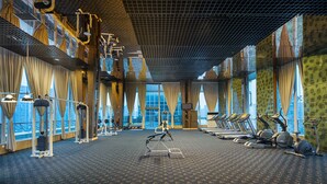 A gym with exercise equipment, large windows, and a patterned carpet. - Holiday Inn Chengdu Century City-WestTower by IHG (Chengdu)