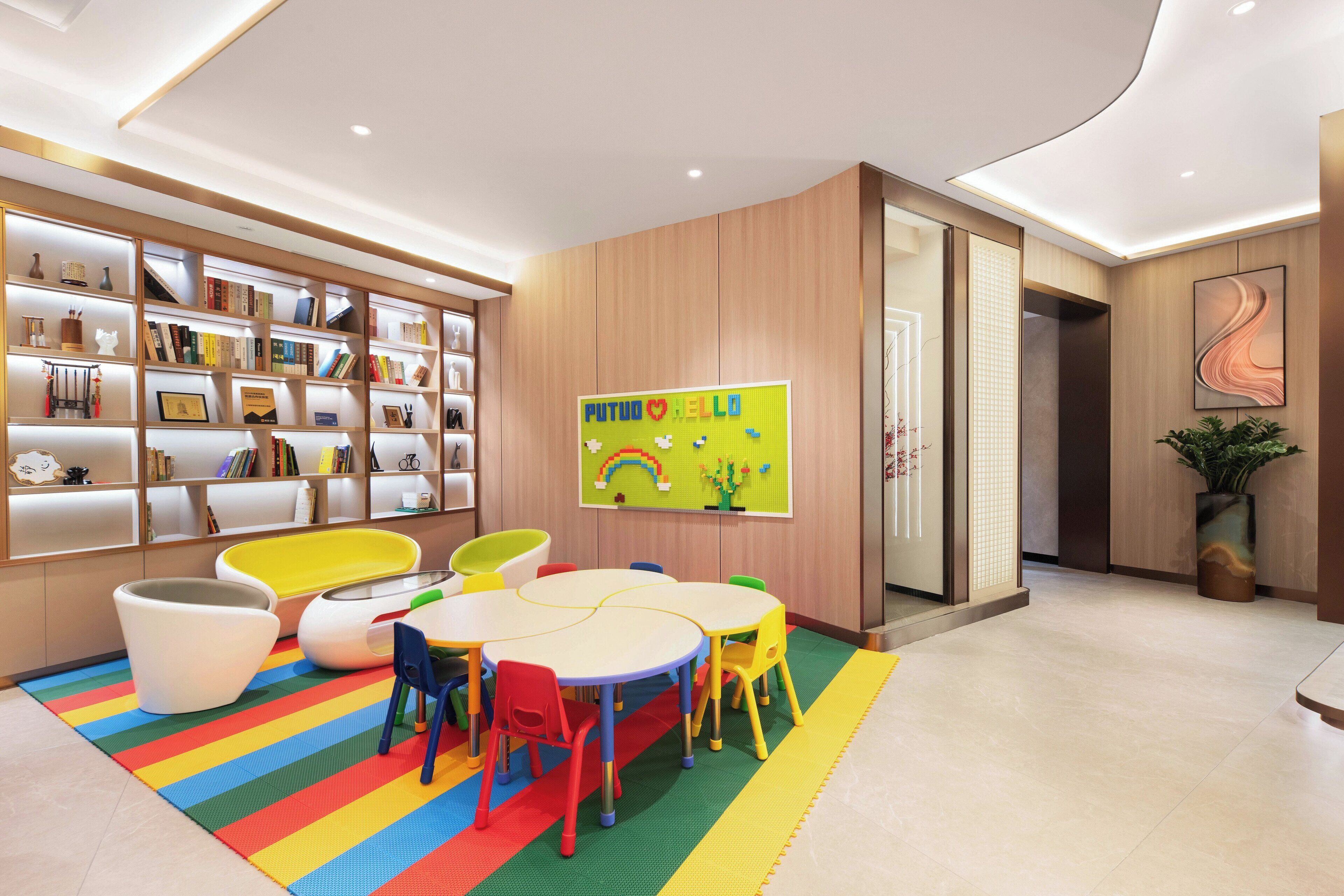 A children's play area with a colorful rug, a white table, and chairs.