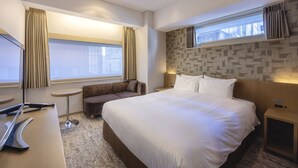 A hotel room with a large bed, a sofa, a desk with a laptop, and a window with curtains. - Hotel Gracery Ginza (Tokyo)