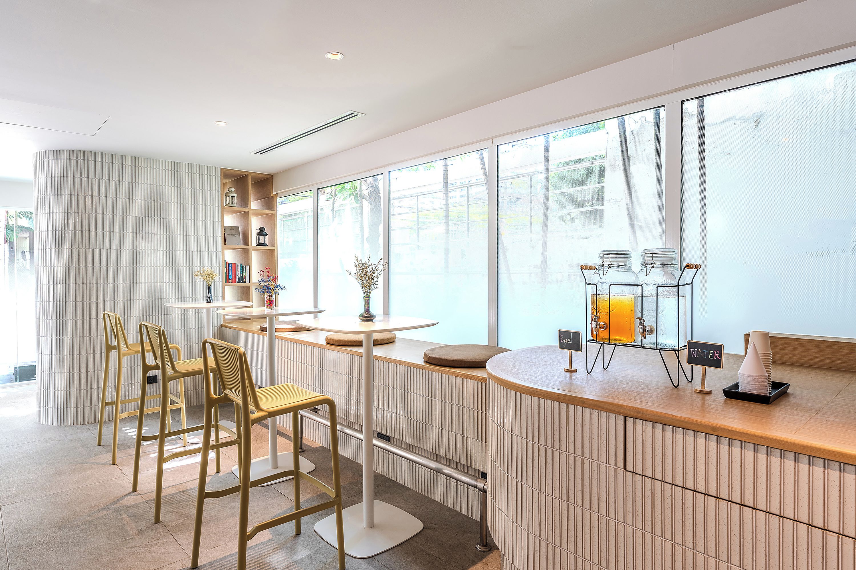 A modern bar area with a counter, stools, and a large window with a view.