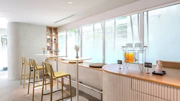 A modern bar area with a counter, stools, and a large window with a view.