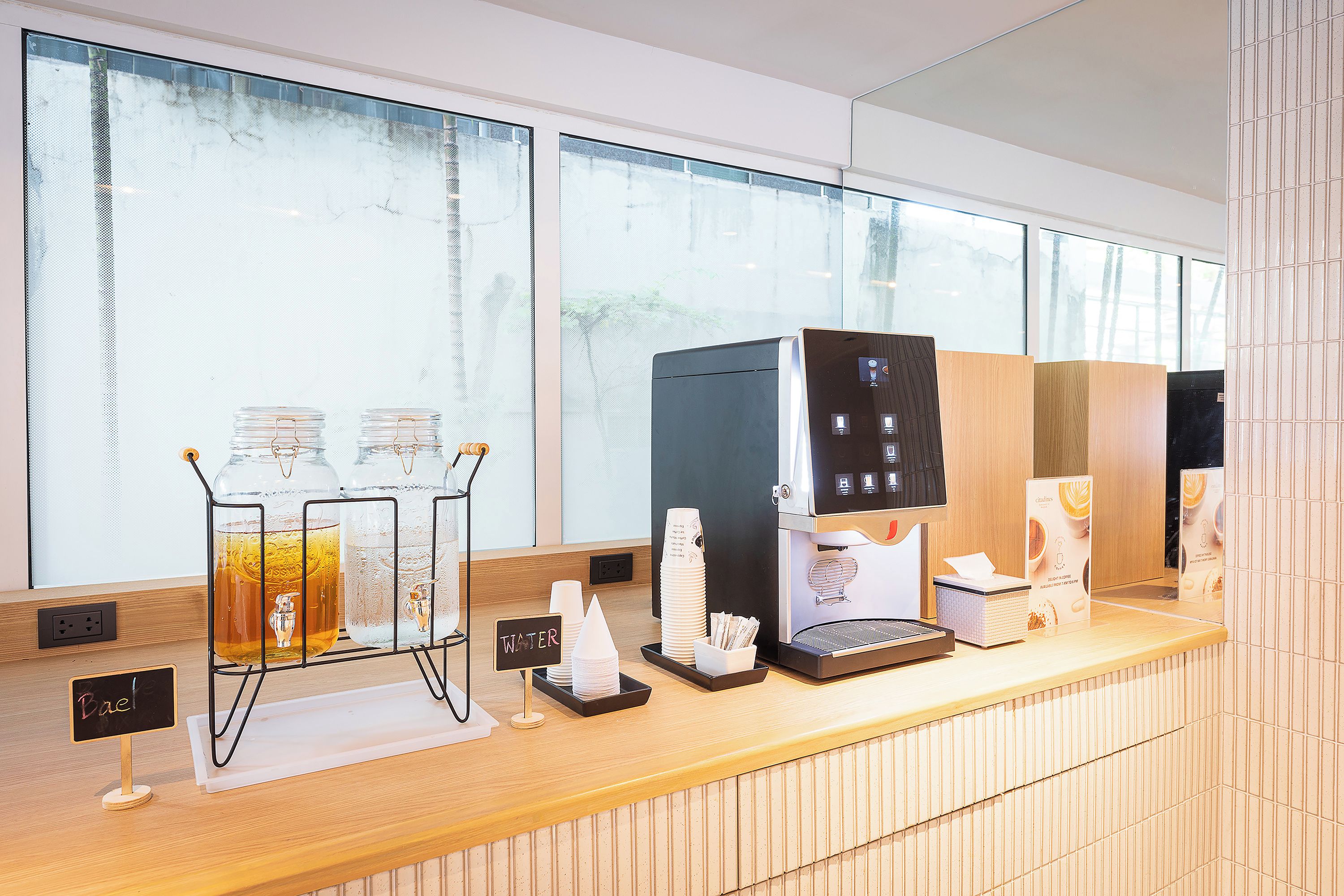 A coffee station with a coffee machine, water dispenser, and glass carafe.