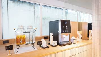 A coffee station with a coffee machine, water dispenser, and glass carafe.