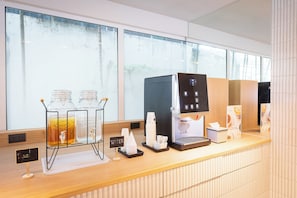 Eine Kaffeestation mit Kaffeemaschine, Wasserspender und Glasbehälter.