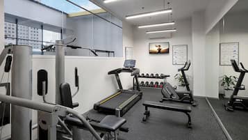 A modern gym with treadmills, dumbbells, and weight machines.