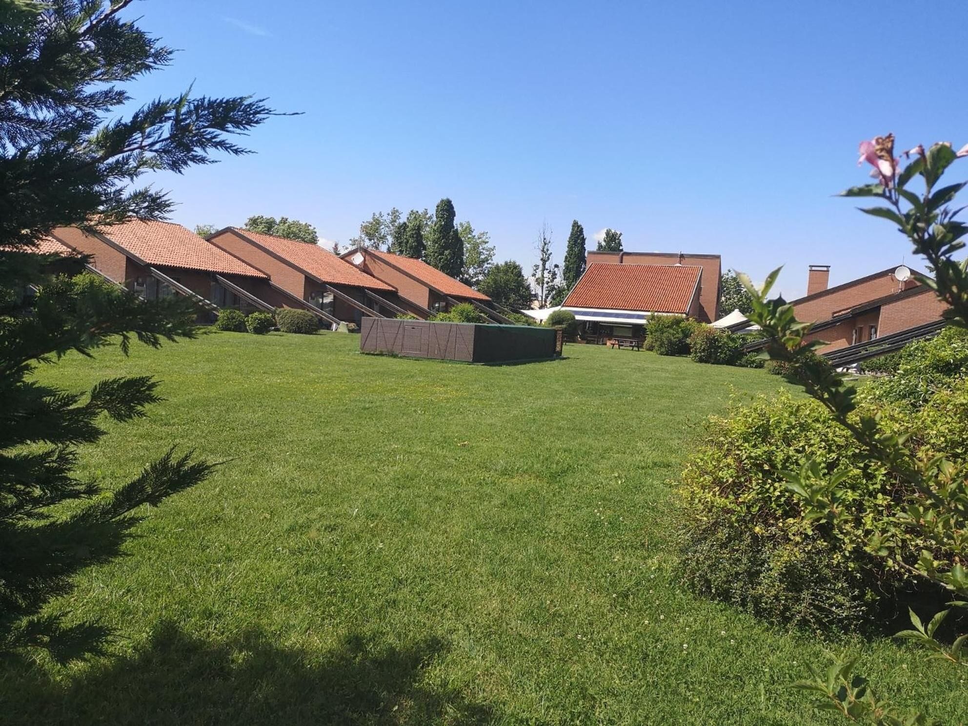 Ett bostadsområde med flera hus, en välskött gräsmatta och ett picknickbord.