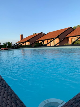 Una piscina al aire libre de temporada, sombrillas