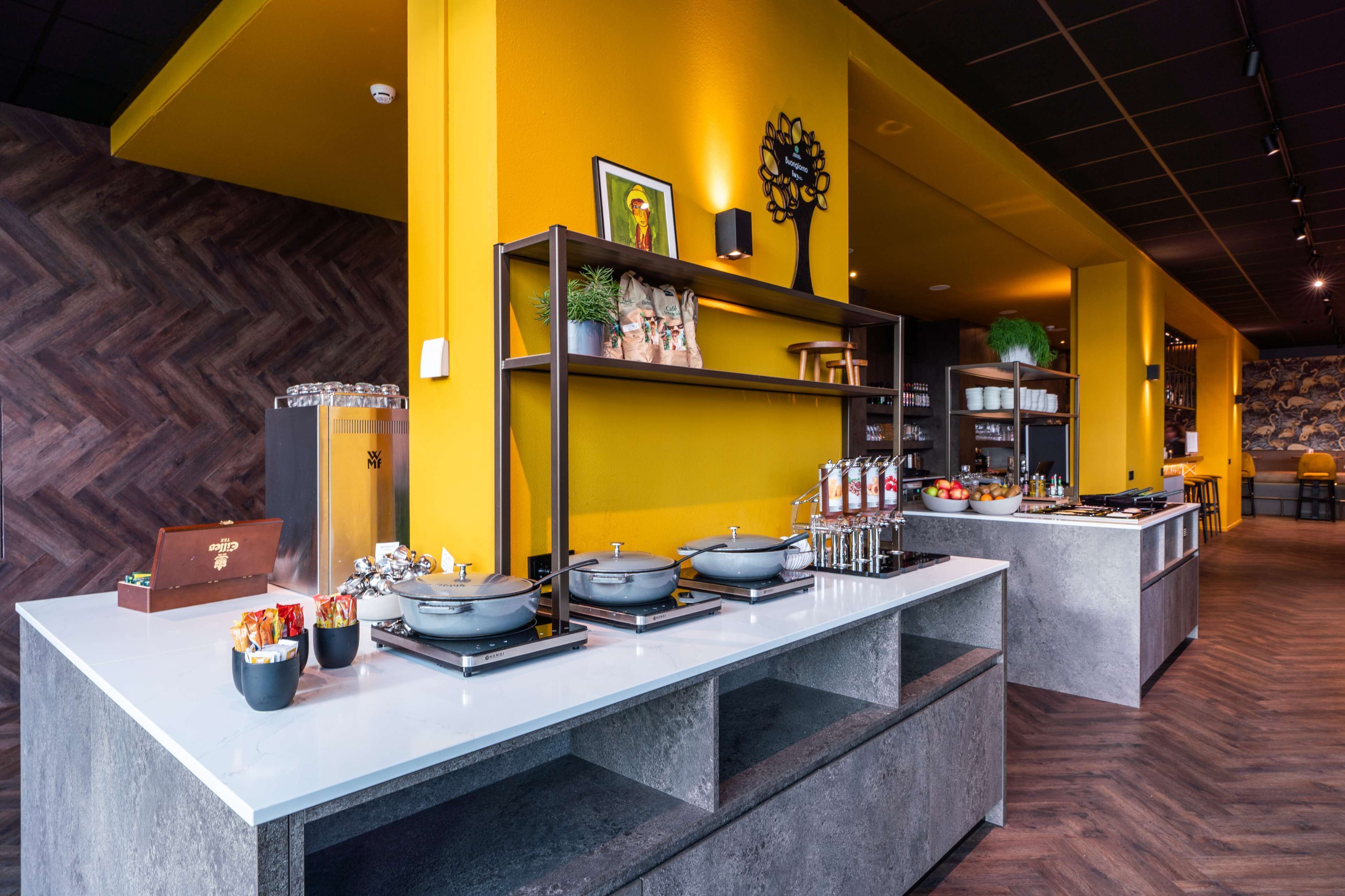 Un área de cocina moderna con una isla central, estantes empotrados y un suelo de madera en espiga.
