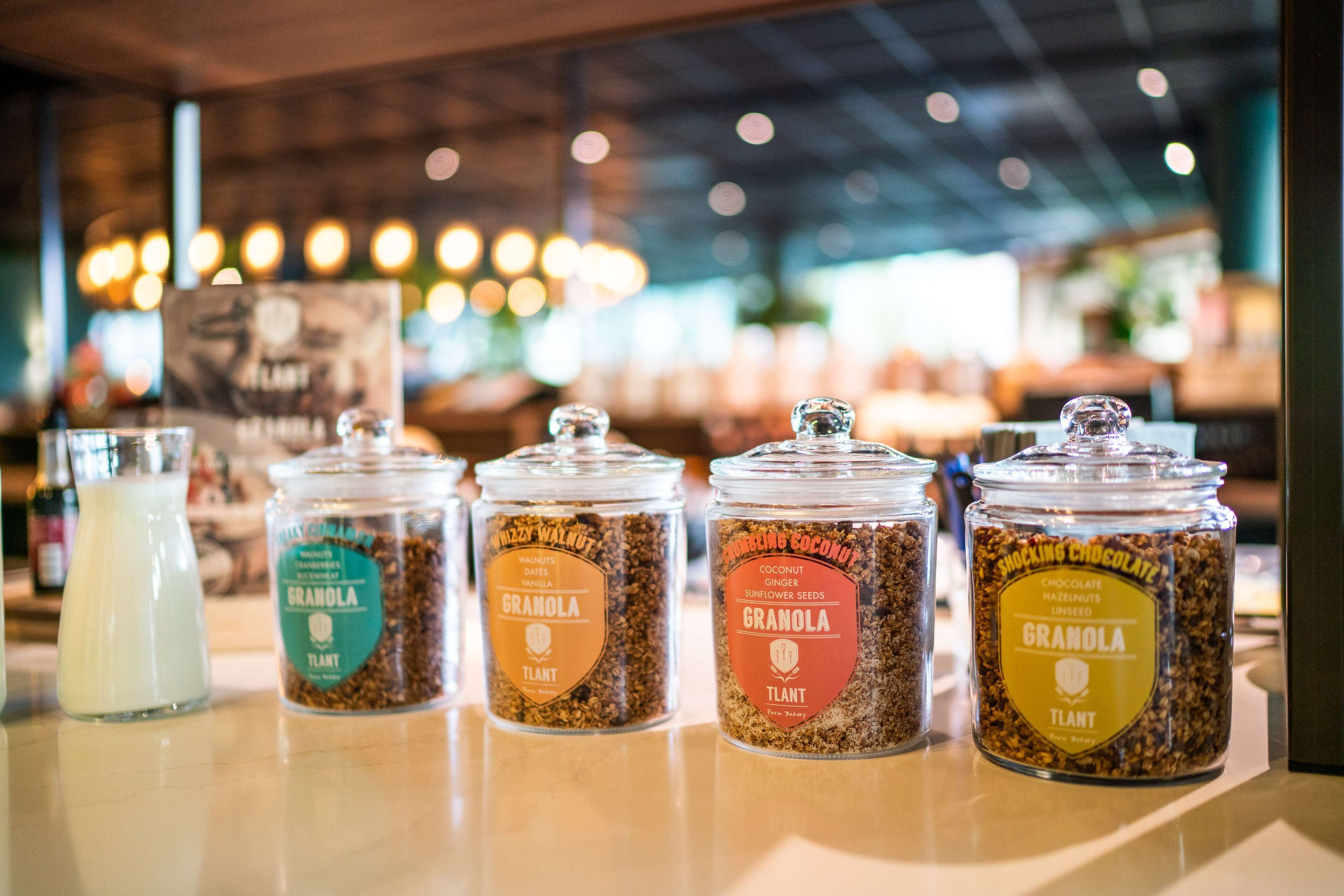 Cuatro frascos de granola con diferentes sabores sobre una encimera.