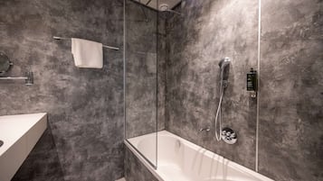 A modern bathroom with a glass-enclosed shower, a freestanding bathtub, and a white vanity.